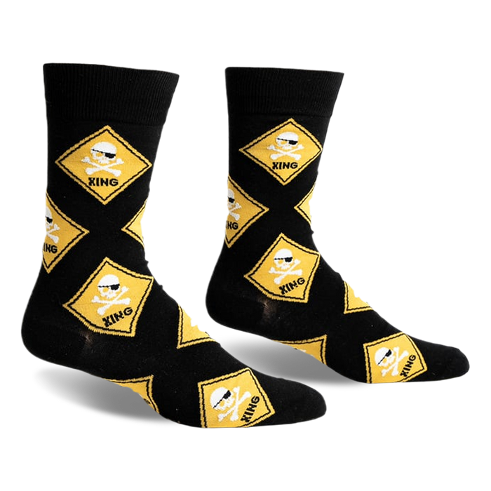 front view of black socks with a yellow skull and crossbones warning sign design.