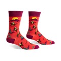 Crew socks in red and burgundy featuring a repeating pattern of cowboys riding horses against a desert sunset background.
