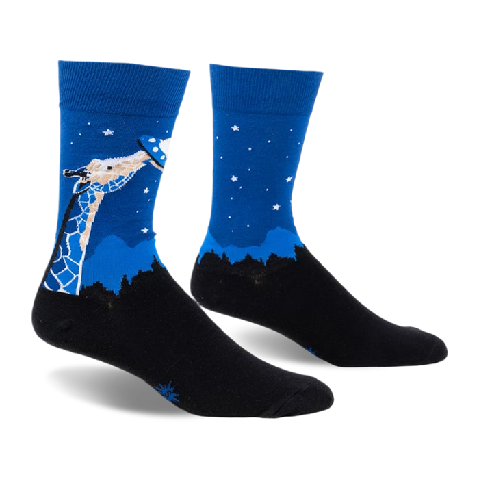 front view of a pair of blue socks with a giraffe reaching up to a flying saucer. the background is blue with white stars. the socks are on a white background.