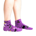 Lifestyle shot: Model wearing the purple 'Witch, Please' socks, showcasing the fit and style.
