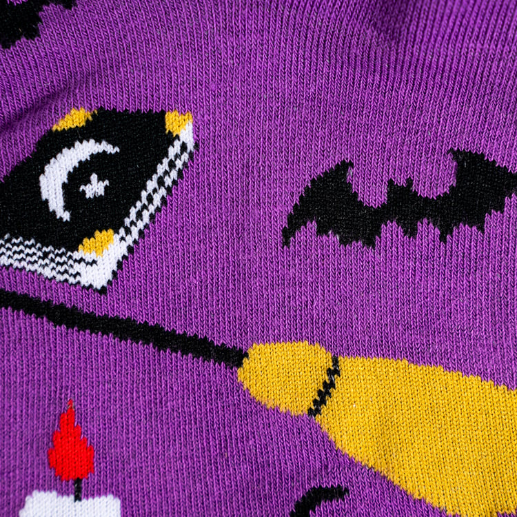 Close-up detail shot of the sock fabric, highlighting the witchy design elements.