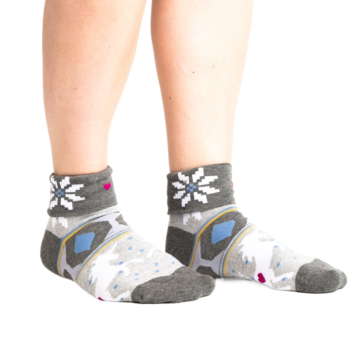 Lifestyle shot: Model wearing the grey and white 'I Believe in Sweater Weather' turn-cuff socks.