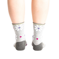 Back view of the socks on a model, showing the design detail on the heel and cuff.