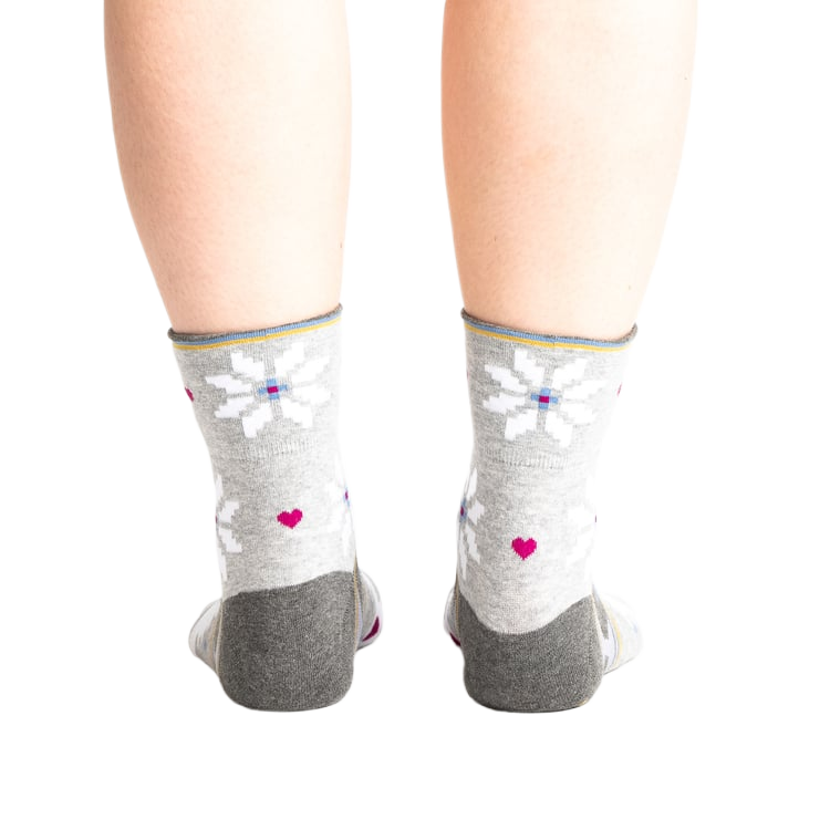 Back view of the socks on a model, showing the design detail on the heel and cuff.