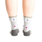 Back view of the socks on a model, showing the design detail on the heel and cuff.