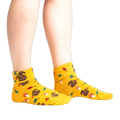 Lifestyle photo: Person's legs wearing the mustard yellow 'I'm Fallin' for You' socks.