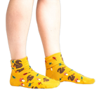 Lifestyle photo: Person's legs wearing the mustard yellow 'I'm Fallin' for You' socks.