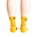 Rear view of a person wearing mustard yellow socks with a squirrel design.