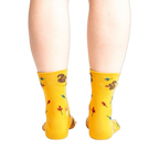 Rear view of a person wearing mustard yellow socks with a squirrel design.