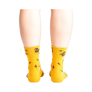 Rear view of a person wearing mustard yellow socks with a squirrel design.