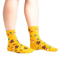 Lifestyle photo: Person's legs wearing the mustard yellow 'I'm Fallin' for You' socks.