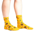 Lifestyle photo: Person's legs wearing the mustard yellow 'I'm Fallin' for You' socks.