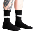 Lifestyle shot showing black Bad Ass Athletic Ribbed socks on a person's legs.