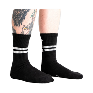 Lifestyle shot showing black Bad Ass Athletic Ribbed socks on a person's legs.