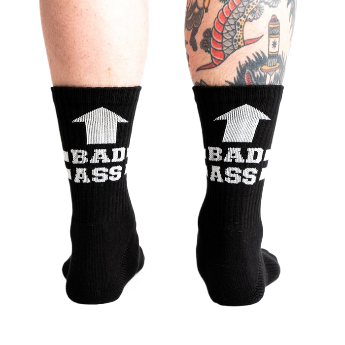 back view of a man wearing black socks with white writing that says 