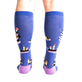 Rear view of model wearing the 'Reading is Magic' knee-high socks, showcasing the full design on both legs.