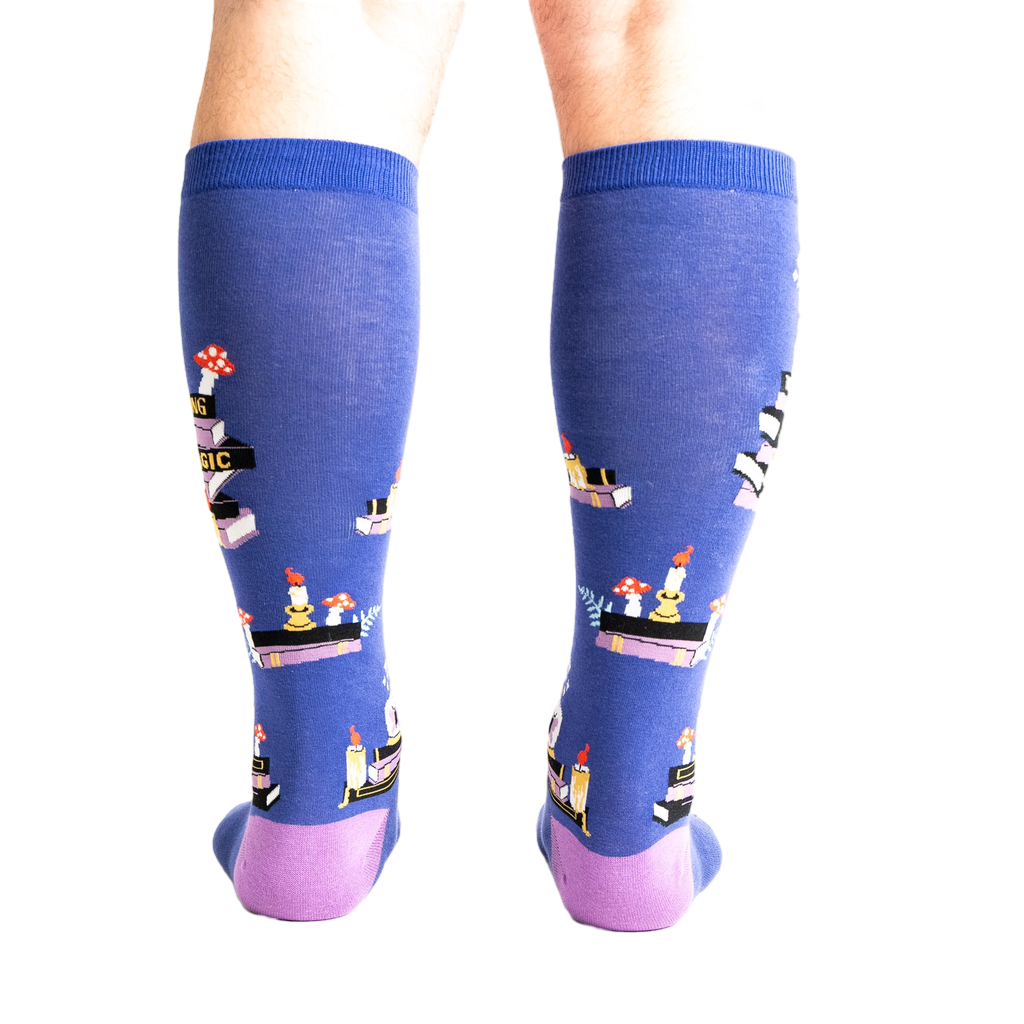 Rear view of model wearing the 'Reading is Magic' knee-high socks, showcasing the full design on both legs.