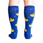 Rear view of a model's legs wearing the blue rubber duckie knee-high socks.