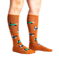 Lifestyle shot of a person's legs wearing the 'Horses Keep Me Stable' knee-high socks. The socks are mustard yellow with a pattern of horses.