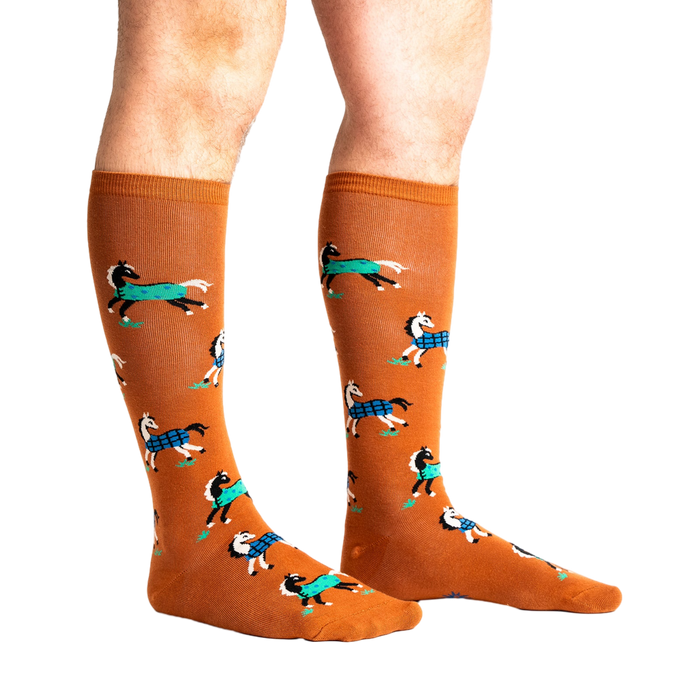Lifestyle shot of a person's legs wearing the 'Horses Keep Me Stable' knee-high socks. The socks are mustard yellow with a pattern of horses.