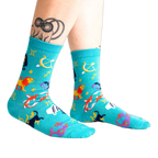 Lifestyle shot of a person wearing the teal zodiac socks.