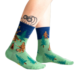 Lifestyle shot of Sasquatch Campout socks on a person's legs. 