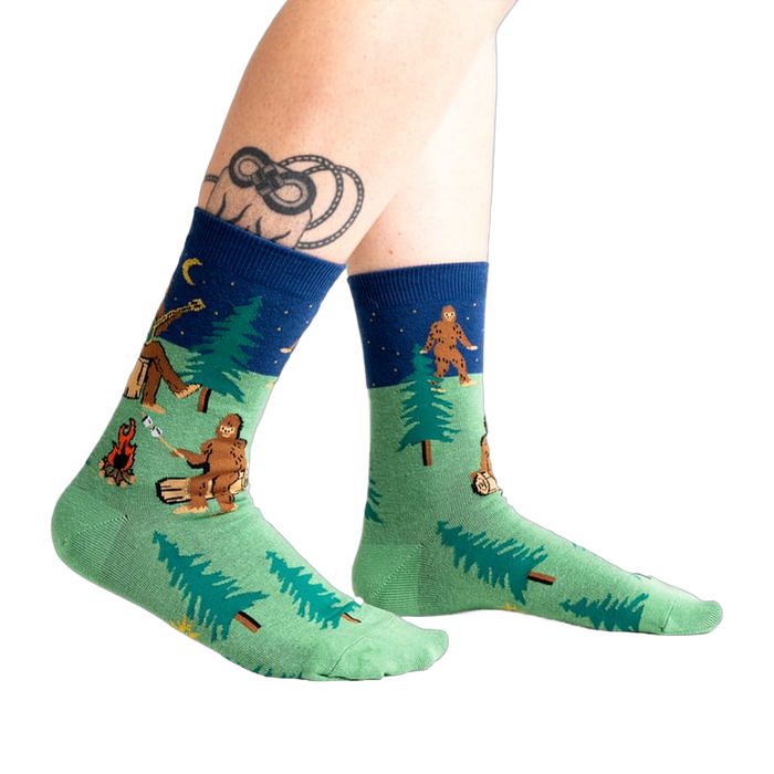 Lifestyle shot of Sasquatch Campout socks on a person's legs. 