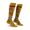 Pair of mustard yellow knee-high socks with playful possum illustrations and the phrase 'Hang in there'.