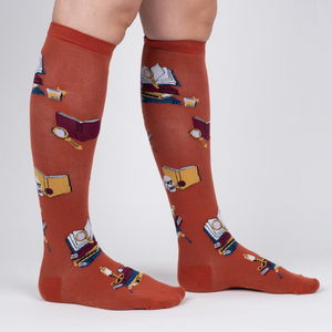 Lifestyle shot: Person wearing burnt orange True Crime knee-high socks.