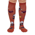 Front view: Pair of burnt orange True Crime knee-high socks on a light grey background.
