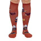 Front view: Pair of burnt orange True Crime knee-high socks on a light grey background.