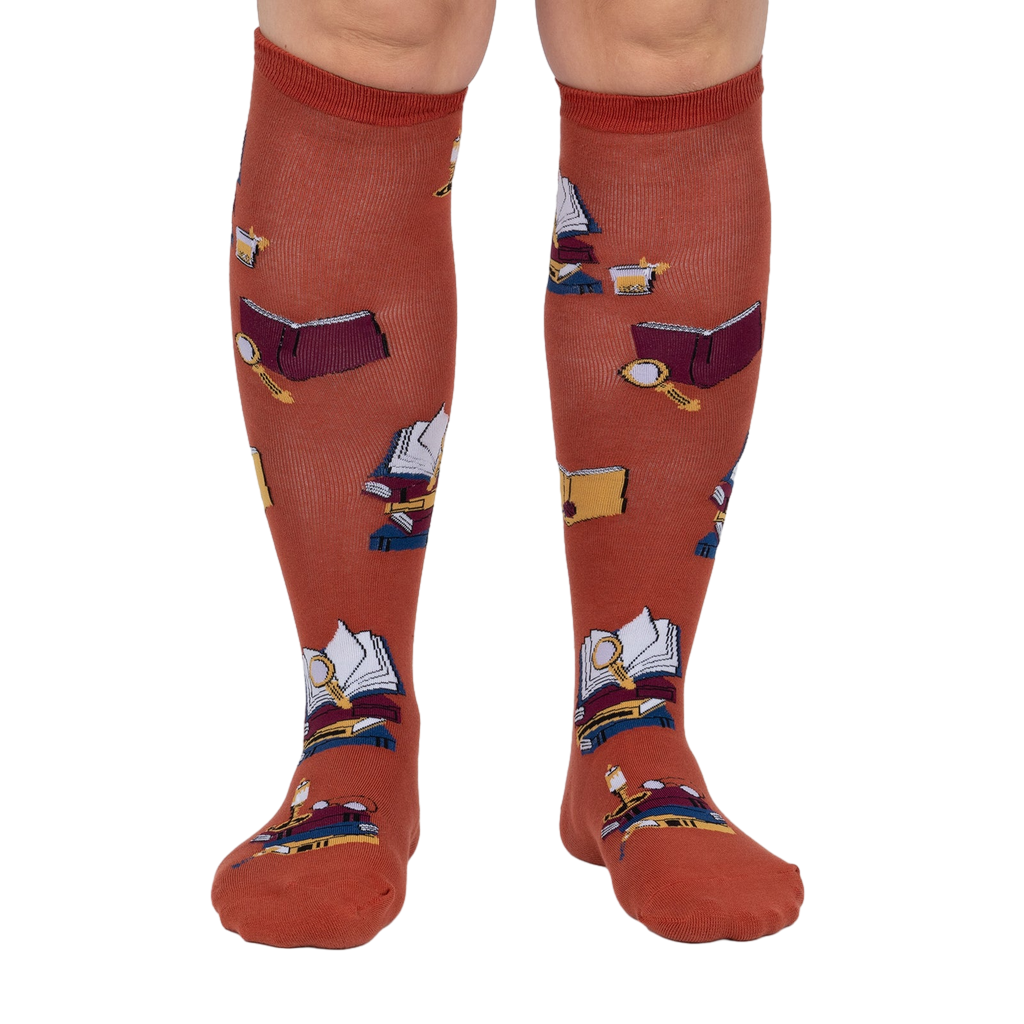 Front view: Pair of burnt orange True Crime knee-high socks on a light grey background.