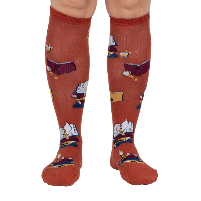 Front view: Pair of burnt orange True Crime knee-high socks on a light grey background.