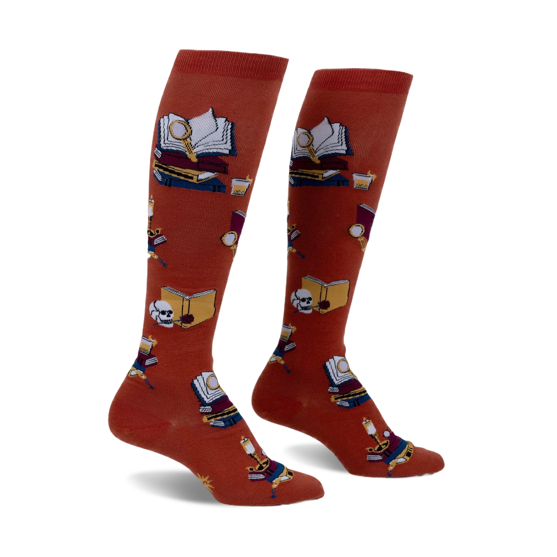 Pair of burnt orange knee-high socks featuring a repeating pattern of books, magnifying glasses, and skulls.