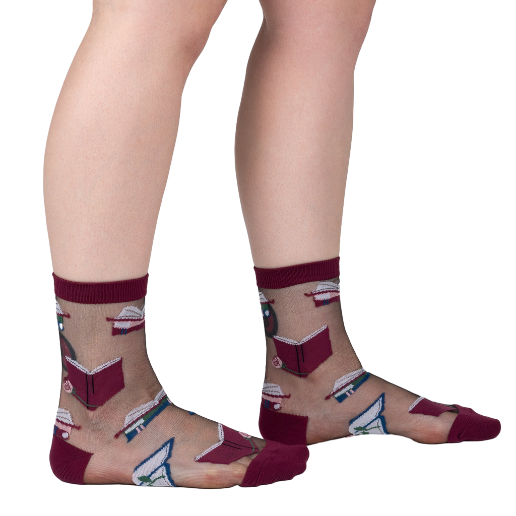 Lifestyle shot showing the socks on a person's legs. The socks are sheer and feature a pattern of books and roses.