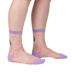 Lifestyle shot showing 'Wrapped in a Bow' socks on a model's legs, highlighting the fit and style.