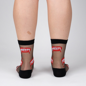 Rear view of model wearing 'Bite Me' socks, highlighting the full design on the back of the socks.