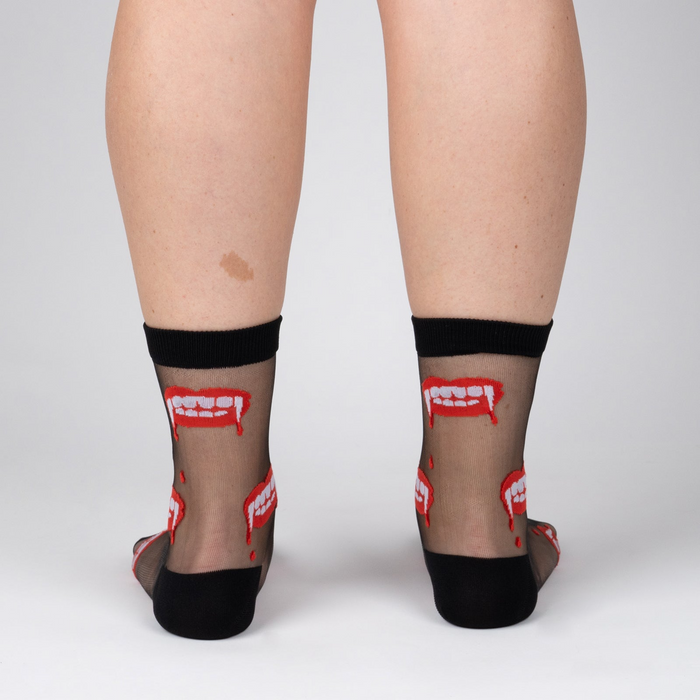 Rear view of model wearing 'Bite Me' socks, highlighting the full design on the back of the socks.