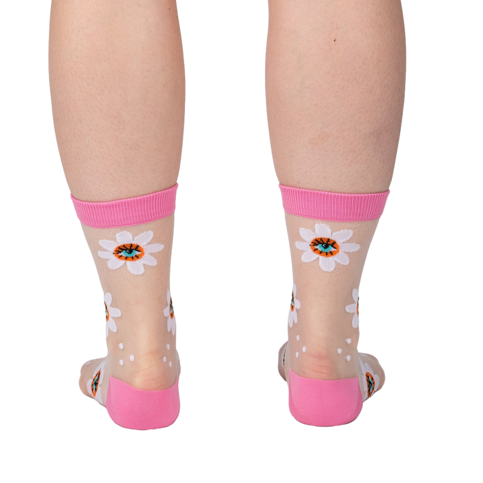 Back view of the socks worn on a person's legs. Shows full view of the daisy pattern.