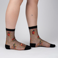 Lifestyle shot of a person's legs wearing the beetle sheer socks.