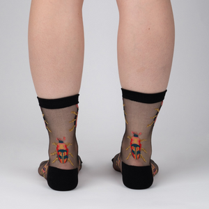 Rear view of a person's legs wearing the beetle sheer socks.