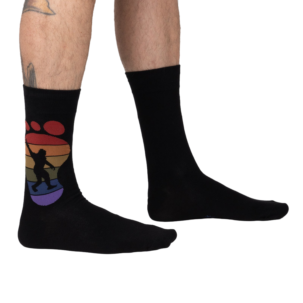 Lifestyle shot showing the 'Squatch and Learn' socks on a person's feet, showcasing the fit and design.