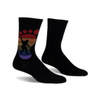 Black crew socks with a rainbow-colored Bigfoot footprint design.  The Bigfoot is silhouetted and holding up a peace sign.