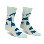 Pair of crew socks. Mint green background with repeating pattern of blue walruses wearing pink hats.