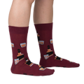 Lifestyle shot showing the Whiskey Business socks on a person's legs.  Burgundy socks with whiskey bottle and glass design.