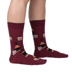 Lifestyle shot showing the Whiskey Business socks on a person's legs.  Burgundy socks with whiskey bottle and glass design.