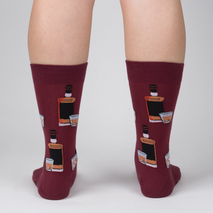 Rear view of the Whiskey Business socks on a person's legs.  Close up of the sock design on a burgundy background.