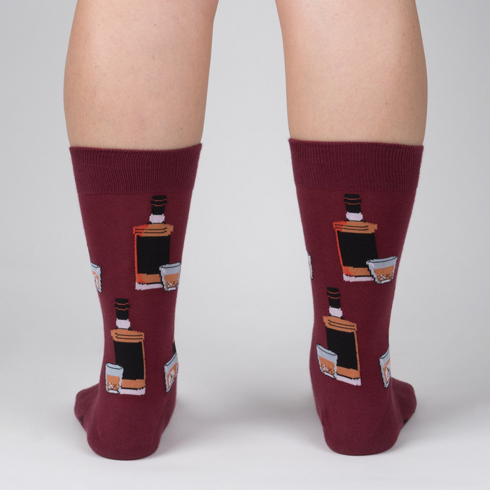 Rear view of the Whiskey Business socks on a person's legs.  Close up of the sock design on a burgundy background.