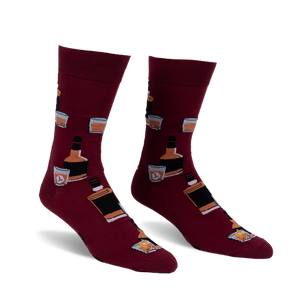 Pair of burgundy crew socks with a repeating pattern of whiskey bottles and glasses. Fun and stylish!
