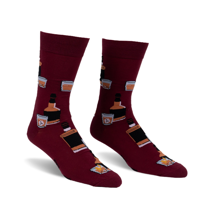 Pair of burgundy crew socks with a repeating pattern of whiskey bottles and glasses. Fun and stylish!